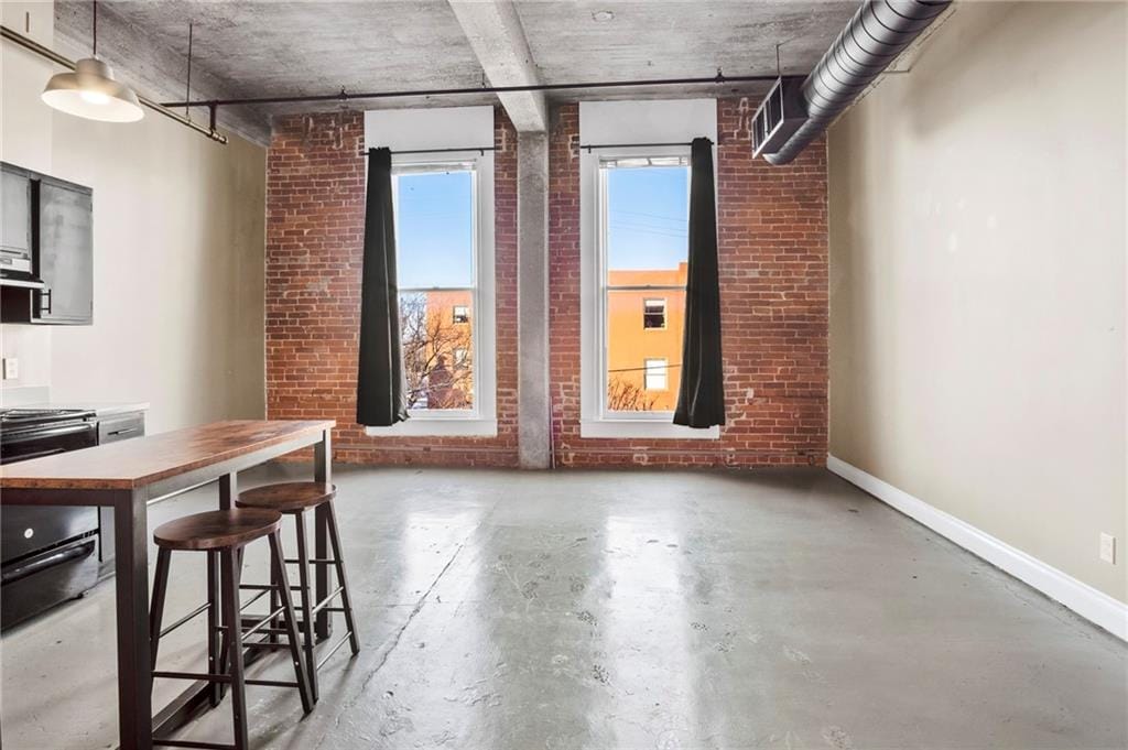 interior space with concrete flooring and brick wall