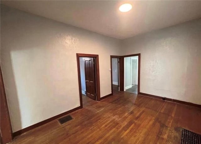 spare room with dark wood-type flooring