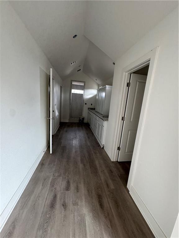 hall with dark hardwood / wood-style floors and vaulted ceiling