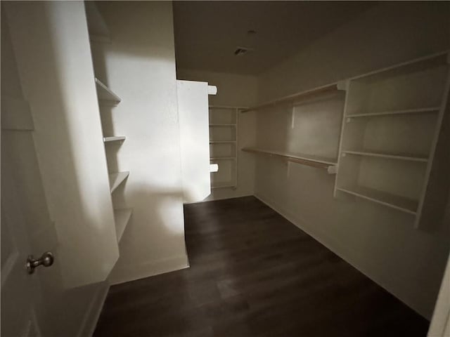 walk in closet with dark hardwood / wood-style flooring