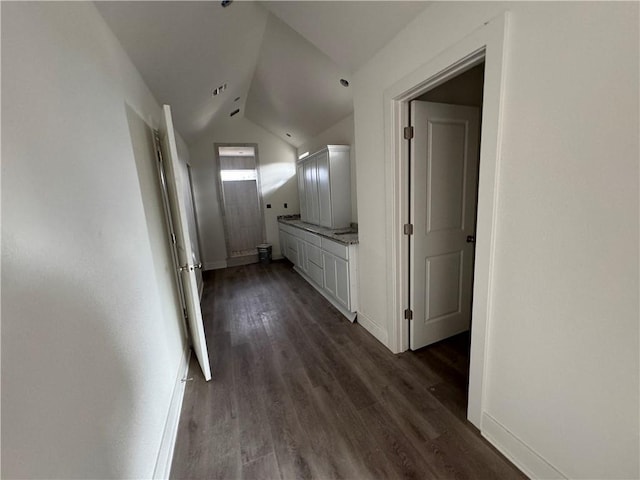 hall with dark hardwood / wood-style flooring and vaulted ceiling