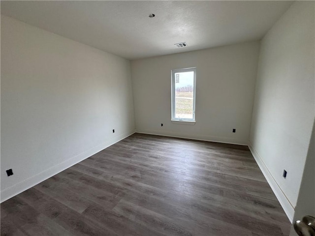 spare room featuring dark hardwood / wood-style floors