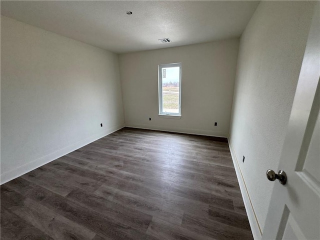 empty room with dark wood-type flooring