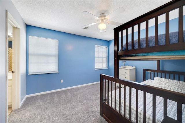 carpeted bedroom featuring ceiling fan and a textured ceiling