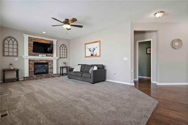 living room with ceiling fan, dark hardwood / wood-style flooring, and a fireplace