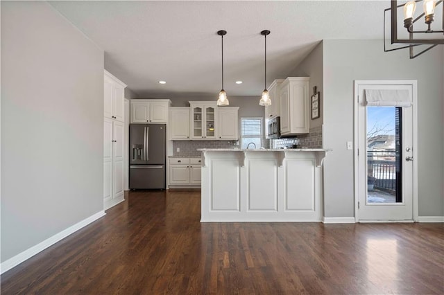 kitchen with tasteful backsplash, a wealth of natural light, stainless steel appliances, and white cabinets