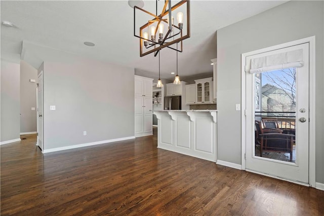 kitchen with pendant lighting, white cabinetry, stainless steel fridge, and dark hardwood / wood-style floors