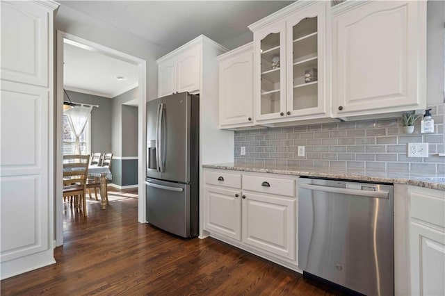 kitchen with stainless steel appliances, dark hardwood / wood-style floors, light stone counters, tasteful backsplash, and white cabinets