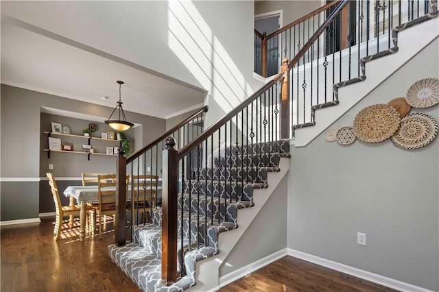 staircase featuring ornamental molding and wood-type flooring