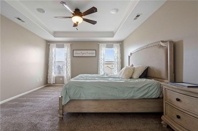 bedroom with multiple windows, dark carpet, a tray ceiling, and ceiling fan