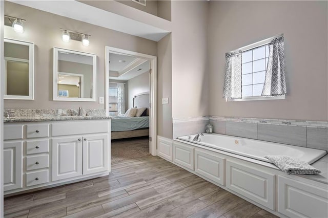 bathroom with vanity, a bathing tub, and a wealth of natural light