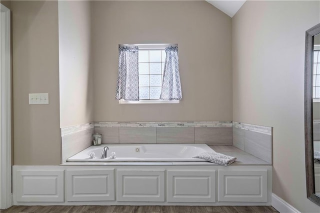 bathroom featuring lofted ceiling and a washtub