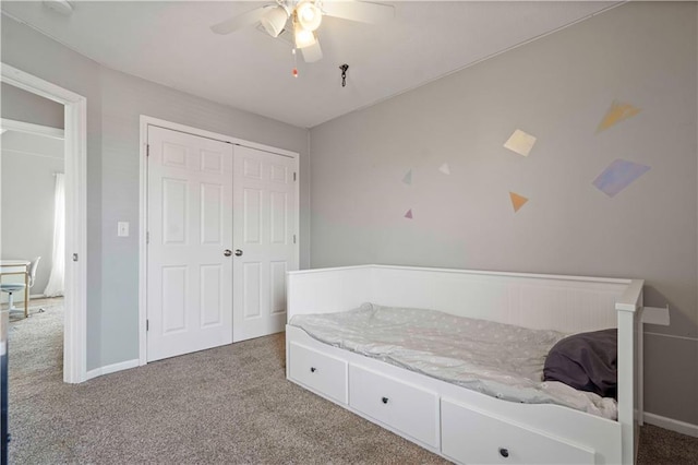 carpeted bedroom with ceiling fan and a closet