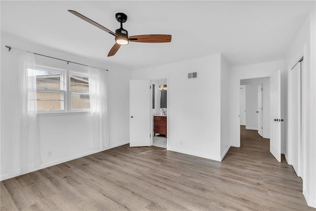 unfurnished bedroom featuring connected bathroom, ceiling fan, and light wood-type flooring