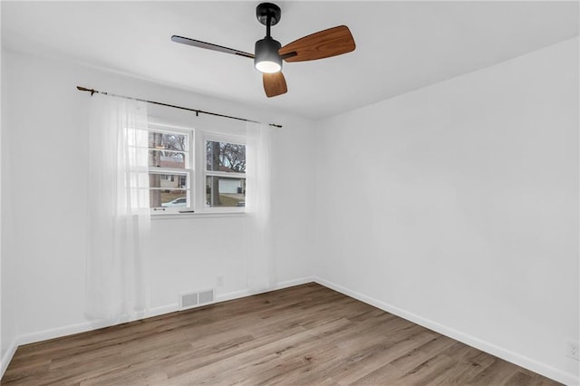 empty room with ceiling fan and light hardwood / wood-style floors