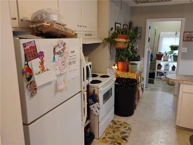 kitchen featuring white appliances, white cabinetry, and exhaust hood