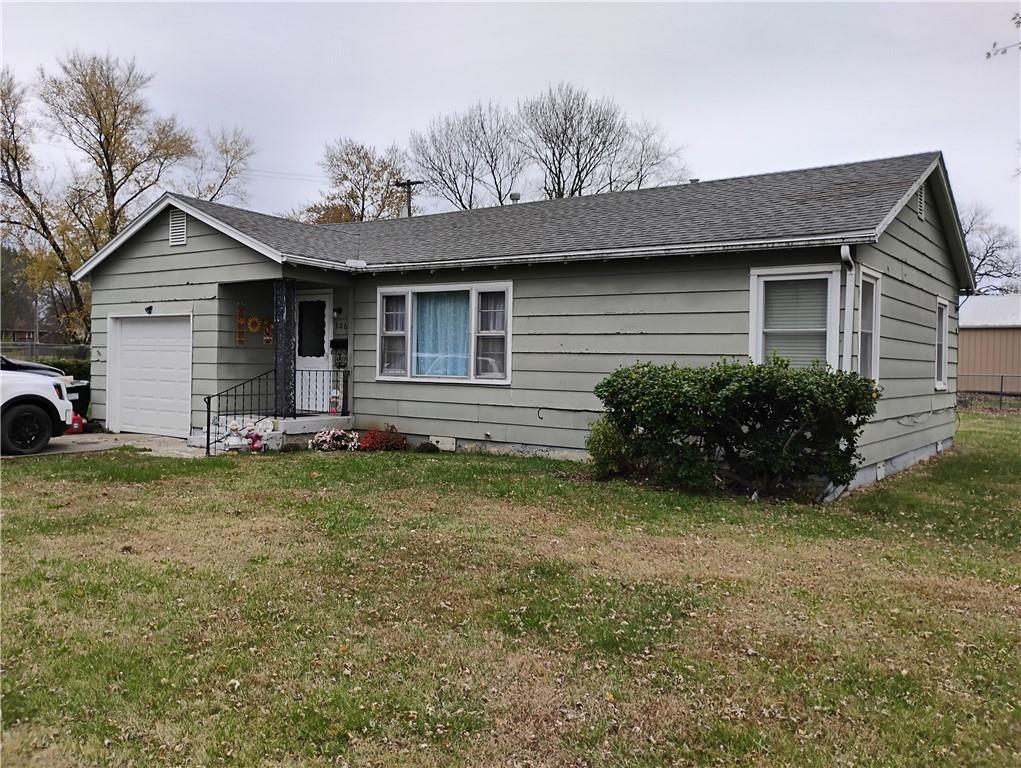 single story home featuring a garage and a front yard