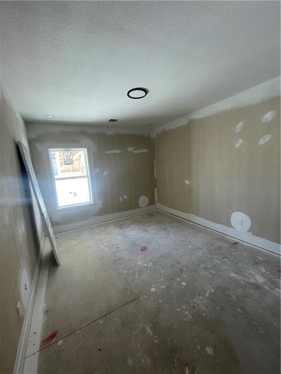 unfurnished room with a textured ceiling