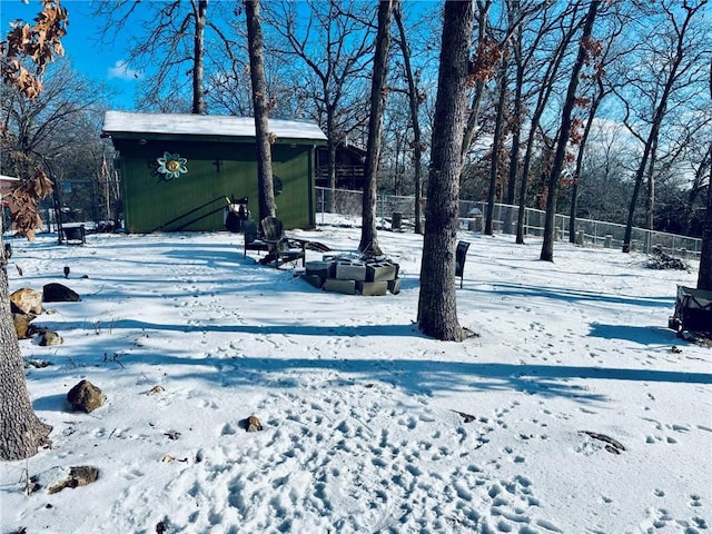 yard layered in snow with a shed