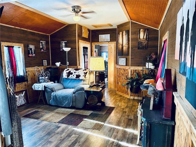 living room featuring vaulted ceiling, wood walls, and wood ceiling