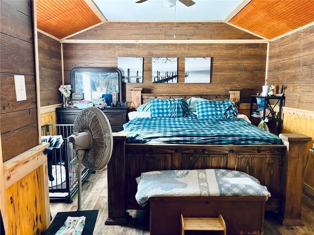 bedroom featuring ceiling fan, wood walls, light wood-type flooring, and wood ceiling