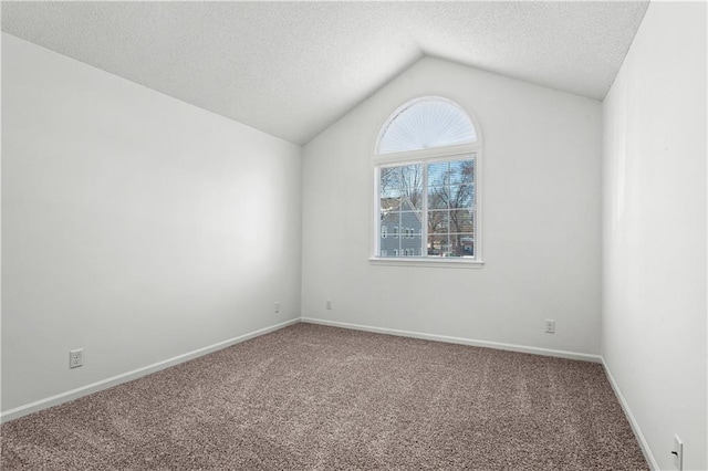 carpeted empty room with lofted ceiling and a textured ceiling