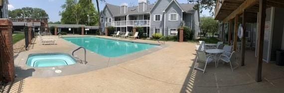 view of swimming pool featuring a hot tub and a patio area