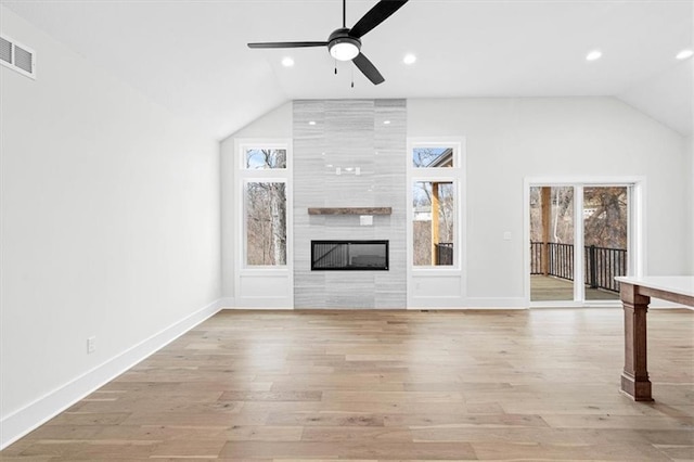 unfurnished living room with a fireplace, light hardwood / wood-style floors, vaulted ceiling, and ceiling fan