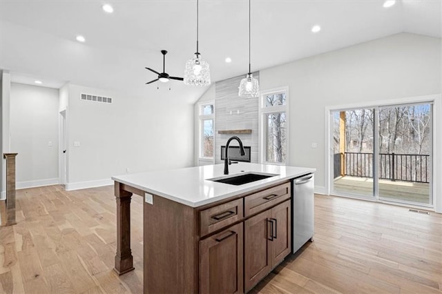 kitchen with dishwasher, a center island with sink, sink, vaulted ceiling, and ceiling fan