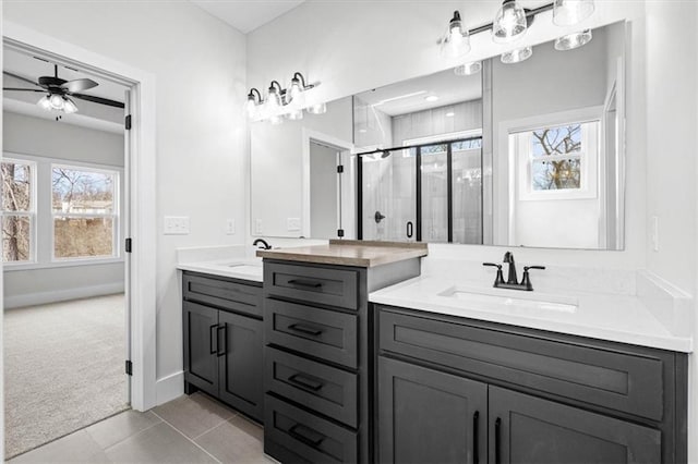 bathroom featuring tile patterned flooring, ceiling fan, a shower with door, and vanity