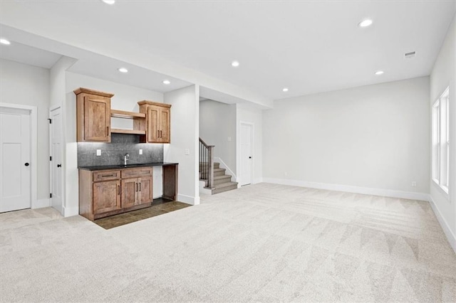 kitchen featuring carpet, decorative backsplash, and sink