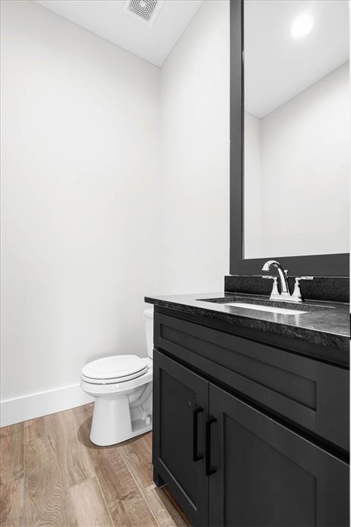 bathroom featuring hardwood / wood-style floors, vanity, and toilet