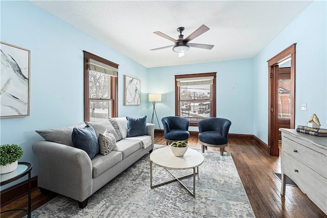 living room with ceiling fan, a wealth of natural light, and dark hardwood / wood-style flooring