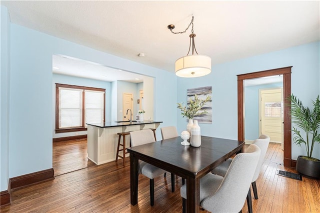 dining room featuring dark wood-type flooring and sink