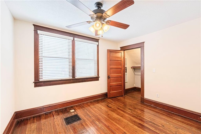 empty room featuring ceiling fan and dark wood-type flooring