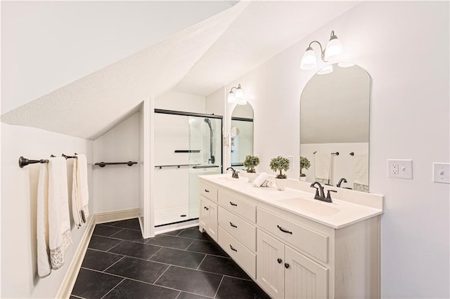 bathroom with tile patterned flooring, vaulted ceiling, vanity, and a shower with door