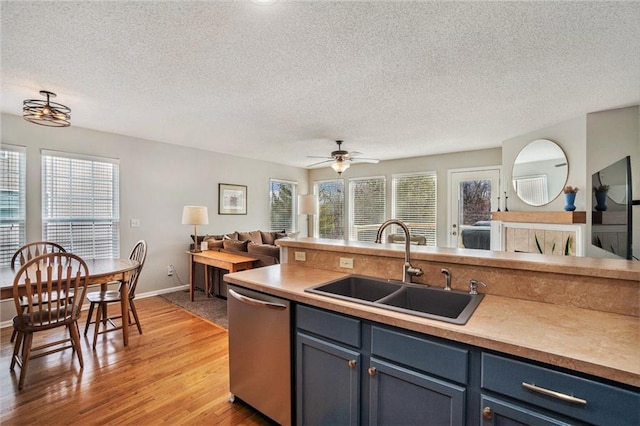 kitchen featuring a wealth of natural light, sink, stainless steel dishwasher, and light wood-type flooring