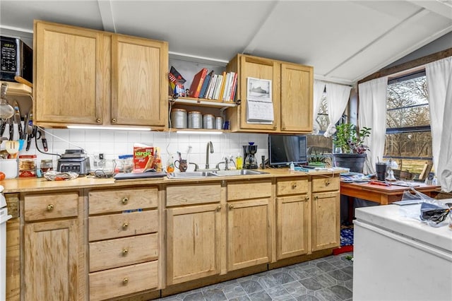 kitchen with backsplash, sink, vaulted ceiling, and light brown cabinets