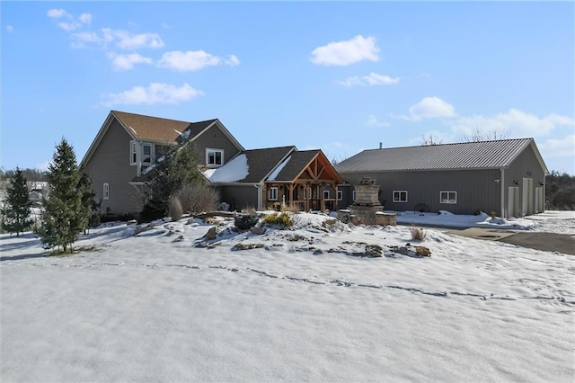 view of snow covered back of property