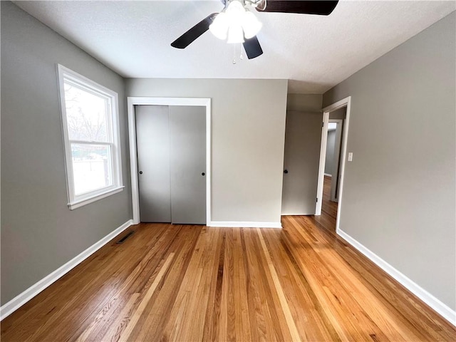 unfurnished bedroom featuring light wood-type flooring, a closet, and ceiling fan