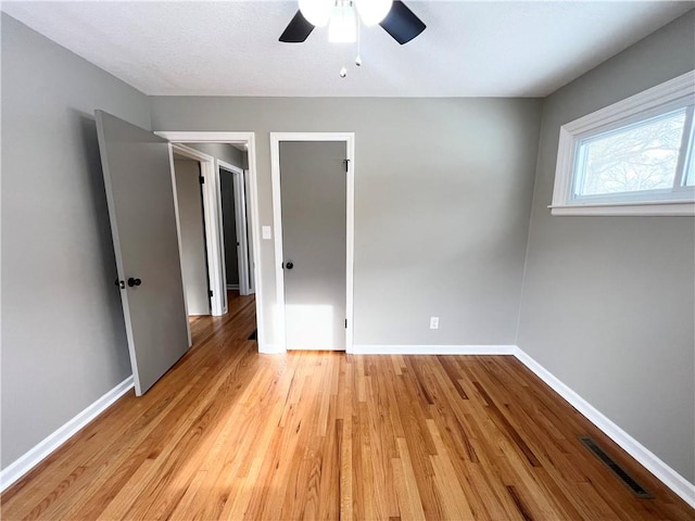 unfurnished bedroom with ceiling fan and light wood-type flooring