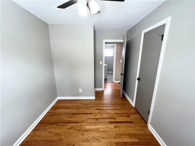 hallway featuring hardwood / wood-style floors and a textured ceiling