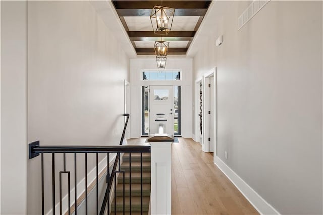 corridor with wood-type flooring and an inviting chandelier