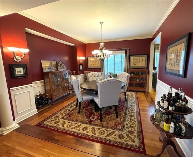 dining room featuring crown molding, a chandelier, and hardwood / wood-style flooring