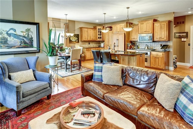 living room featuring an inviting chandelier and light wood-type flooring