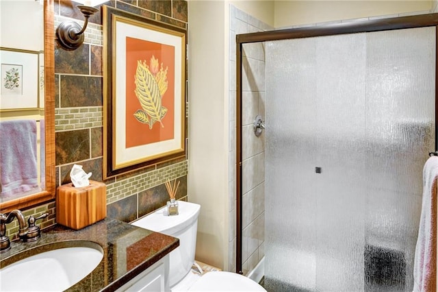 bathroom featuring tasteful backsplash, vanity, toilet, and walk in shower