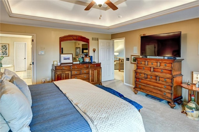 carpeted bedroom with a tray ceiling, ornamental molding, and ceiling fan