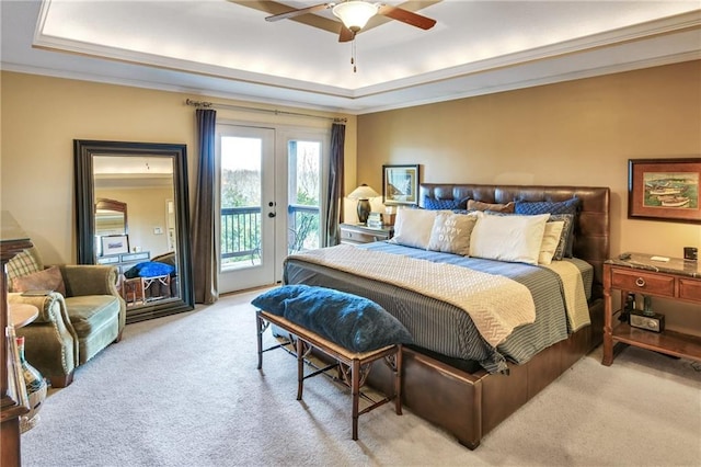 bedroom featuring access to exterior, a tray ceiling, crown molding, light carpet, and french doors