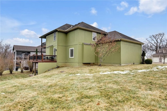 rear view of property with a wooden deck and a lawn