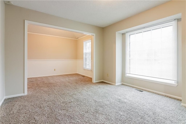 carpeted spare room featuring plenty of natural light